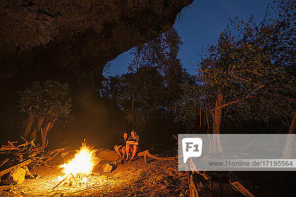 mature couple enjoying camp fire in Laos