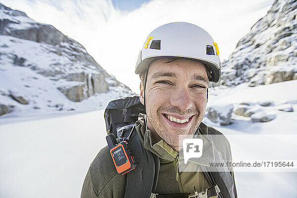 Porträt eines Bergsteigers in den Bergen mit Helm  GPS und Rucksack