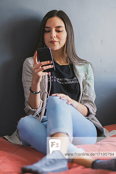 Young woman checking and typing on her cell phone.