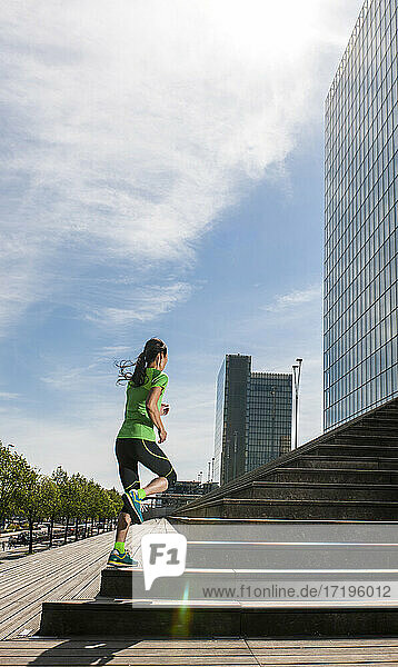 Woman running up wooden stairs in Paris