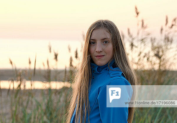 Portrait of young teen girl in hooded jacket at the beach