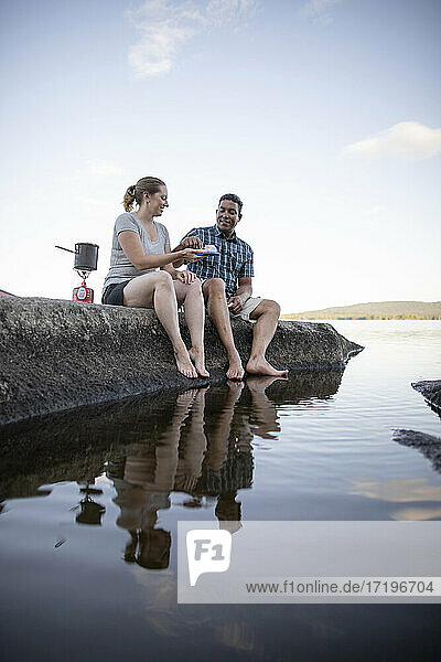 Ein Paar kocht und isst und taucht die Zehen in den See  Bald Mountain Pond  Maine