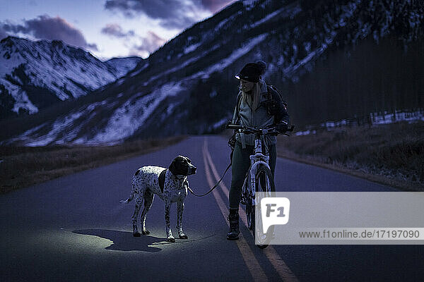 Woman cycling with dog during vacation