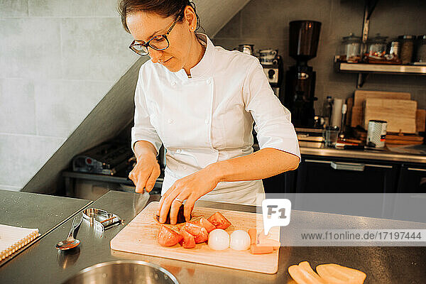 Female chef cutting vegetables in restaurant kitchen