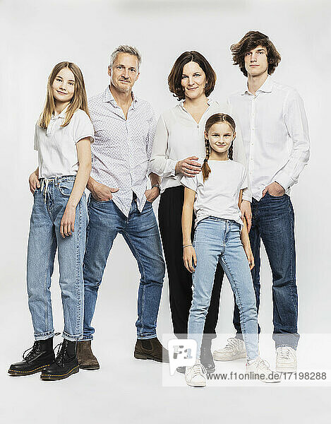 Happy family with children standing against white background