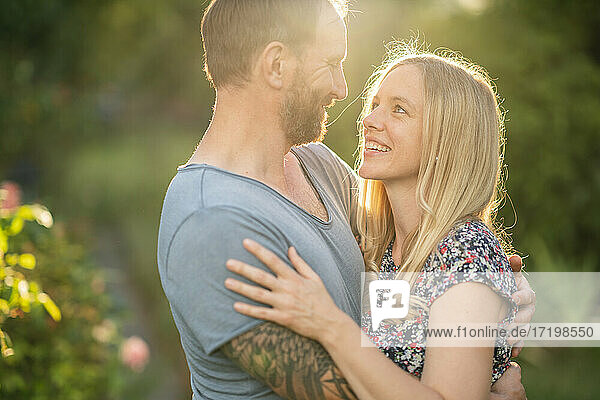 Glückliches Paar umarmt sich im Garten
