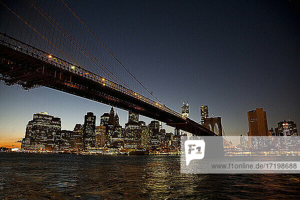 USA  New York  New York City  Brooklyn Bridge bei Nacht mit der Skyline von Manhattan im Hintergrund