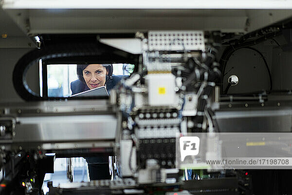 Female entrepreneur examining machinery at factory
