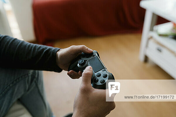 Man with game controller playing video game at home