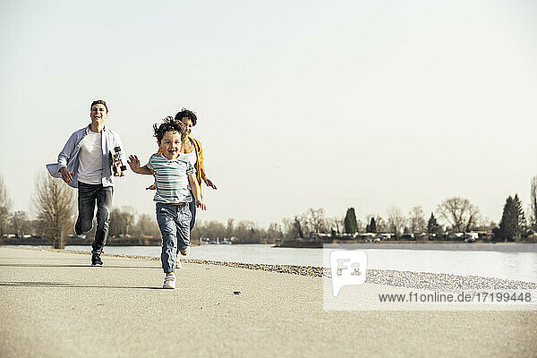 Happy son running with parents in background on road