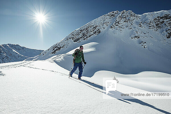 Mann beim Skitourengehen auf der schneebedeckten Steinkarspitze  Lechtaler Alpen  Tirol  Österreich