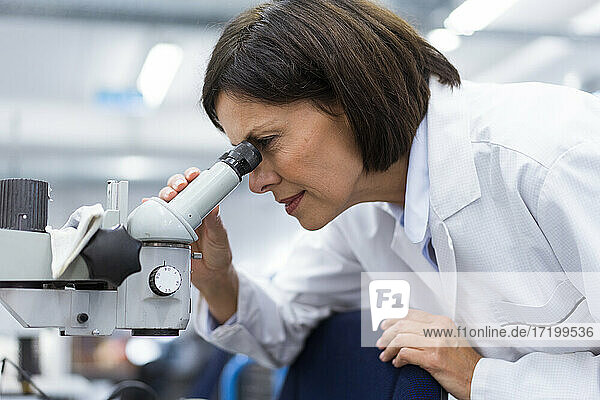 Female scientist using microscope while working in laboratory