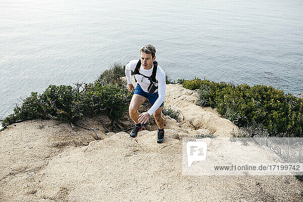 Determined man running on rocks near sea