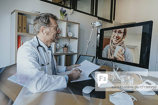 Mitarbeiter des Gesundheitswesens im Gespräch mit einem Patienten per Videoanruf am Computer in einer Arztpraxis