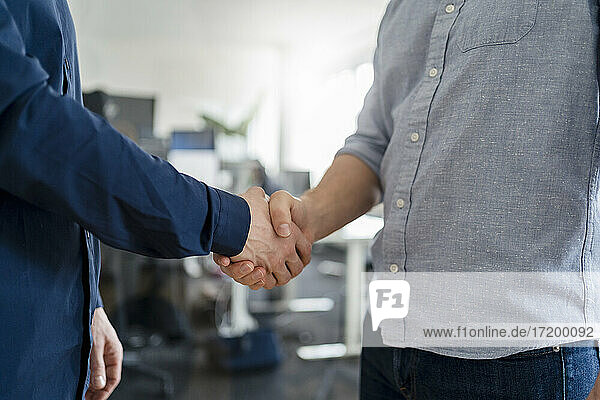 Männliche Unternehmer beim Händeschütteln im Büro
