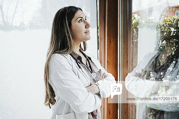 Female medical professional with arms crossed looking away