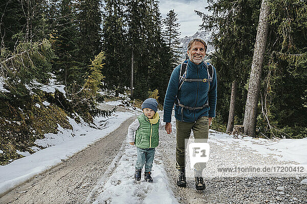 Boy with smiling father hiking in forest at Salzburger Land  Austria