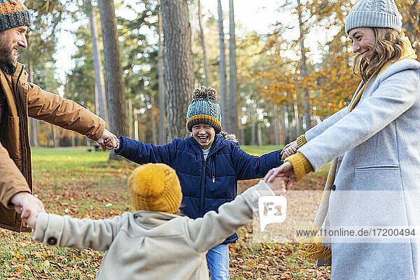 Happy family enjoying while playing in forest