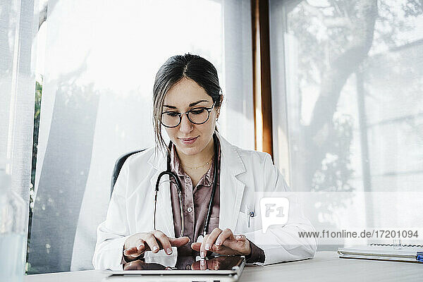 Ärztin bei der Arbeit an einem digitalen Tablet im Krankenhaus