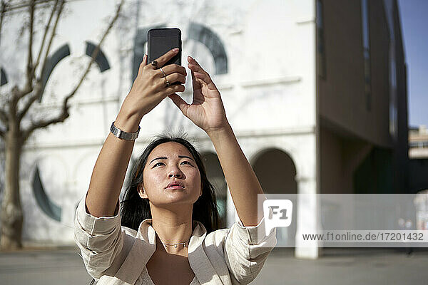 Schöne Frau nimmt Selfie durch Handy auf sonnigen Tag