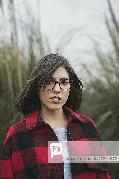 Schöne junge Frau mit Brille auf einem landwirtschaftlichen Feld