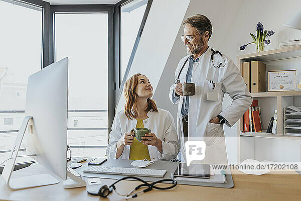 Lächelnde Ärzte bei einem Kaffee im Büro