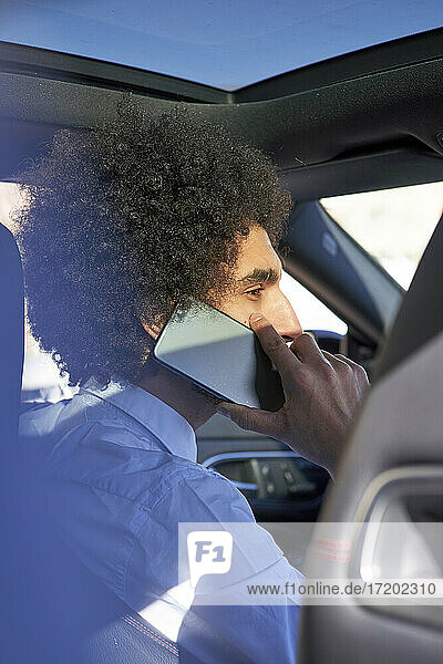 Businessman talking on smart phone while sitting in car