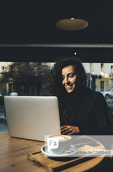 Geschäftsfrau mit Laptop in einem Café sitzend