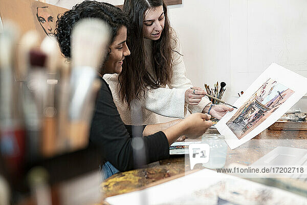 Junge Malerinnen diskutieren in einem Atelier über Malerei