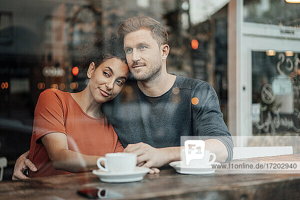 Paar schaut weg  während es zusammen im Café sitzt