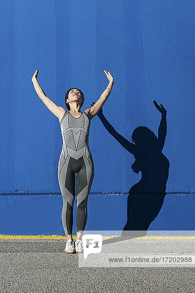 Frau trainiert gegen blaue Wand