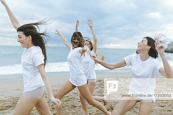 Cheerful female friends enjoying at beach during vacations