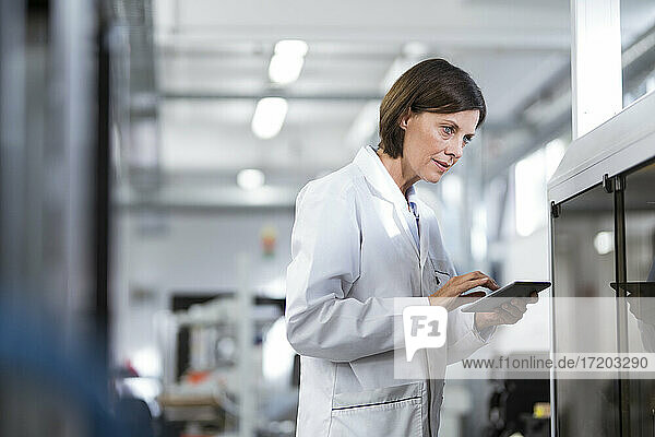 Mature female technician using digital tablet at laboratory