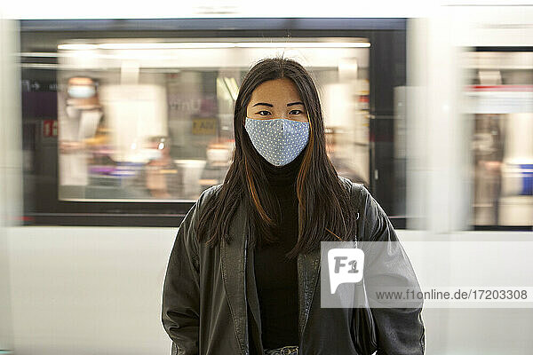 Young woman during pandemic with moving train in background
