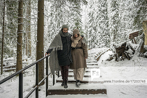 Paar in Decke gehend auf Treppe zusammen im Wald