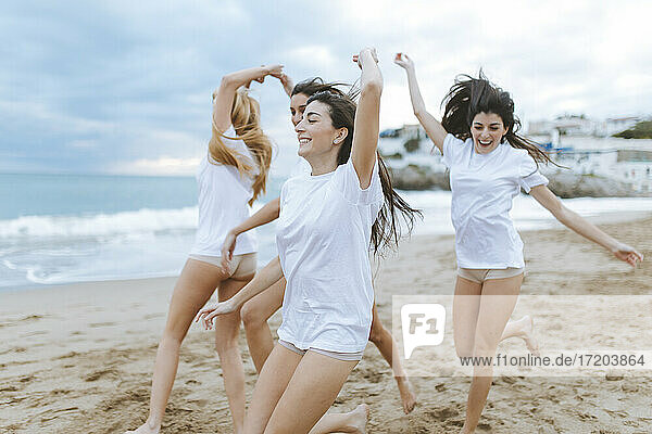 Cheerful female friends having fun at beach during vacations