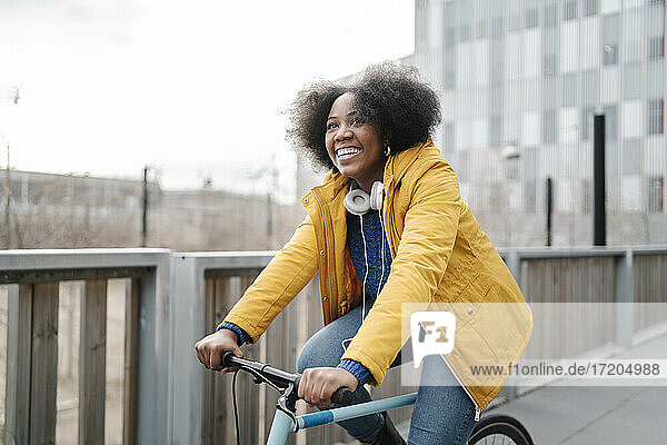 Smiling woman cycling on footpath