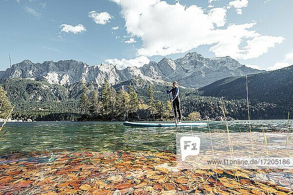 Germany  Bavaria  Garmisch Partenkirchen  Young woman stand up paddling on Lake Eibsee