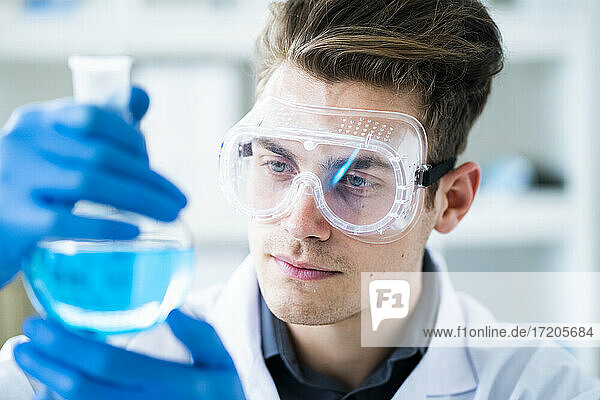 Handsome male scientist examining chemical in laboratory