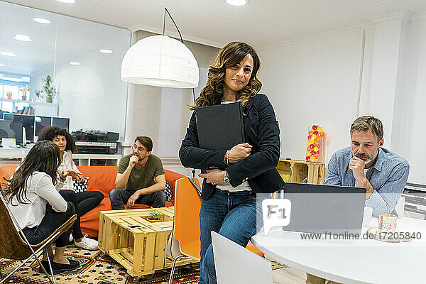 Multiethnische Unternehmerinnen und Unternehmer diskutieren in der Lobby ihres Büros