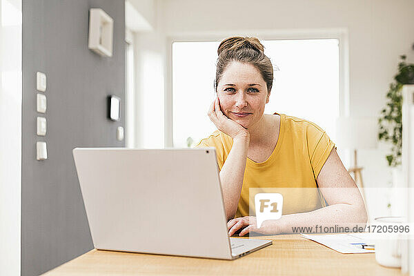 Female entrepreneur with laptop sitting at desk