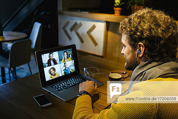 Geschäftsmann führt einen Videoanruf auf einem Laptop  während er in einem Café sitzt