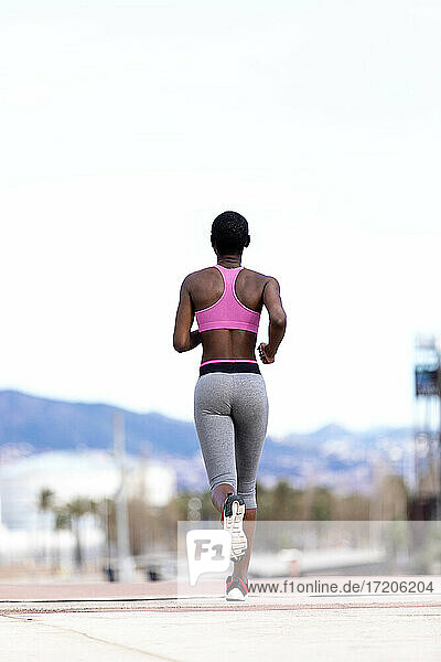 Sportliche Frau läuft auf der Straße in der Stadt