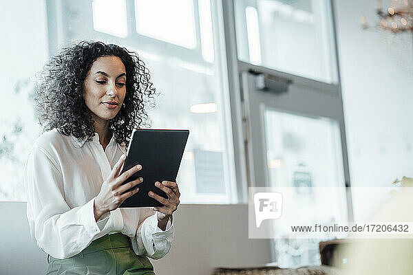 Geschäftsfrau  die ein digitales Tablet benutzt  während sie in einem Café sitzt