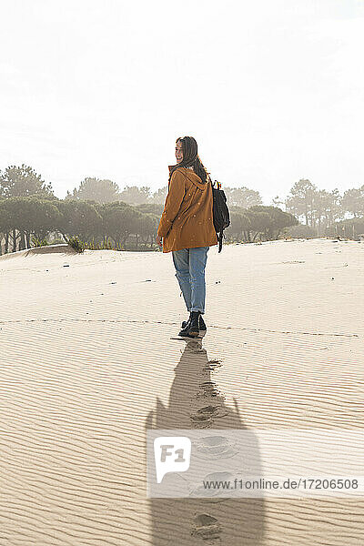Fußabdrücke einer jungen Frau beim Spaziergang am Strand