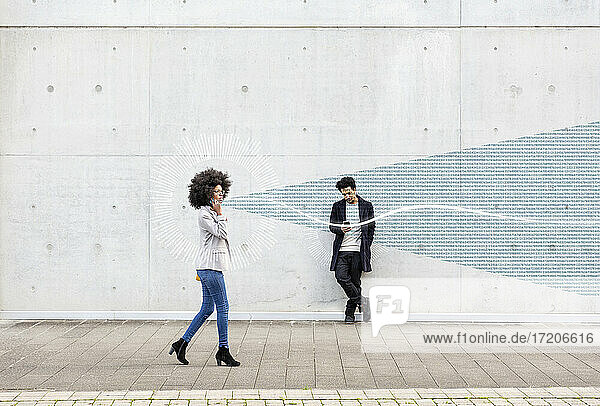 Graphic visualization of data exchanged by man and woman using smart phones outdoors