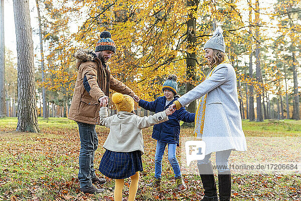 Kinder halten die Hand der Eltern beim Spielen im Wald