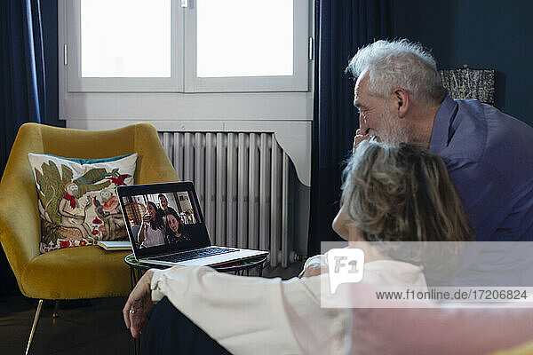 Älteres Ehepaar unterhält sich zu Hause mit der Familie per Videoanruf auf dem Laptop