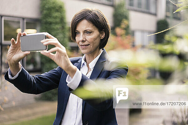 Geschäftsfrau  die ein Selfie macht  während sie im Büropark steht
