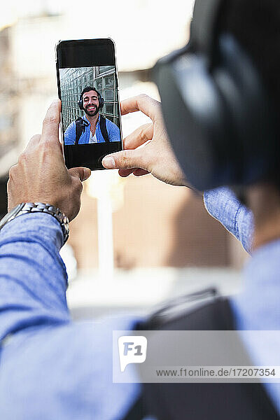Businessman taking selfie through smart phone